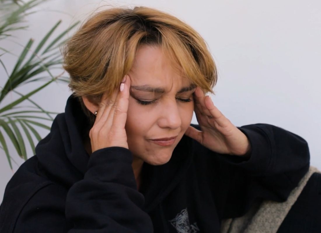 devojka se drži za glavu od bola