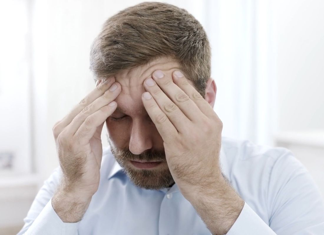 momak se drži rukama za glavu